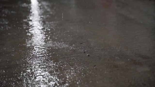 Water is dripping down from the roof inside a tunnel with flourescent light in the celling in slow motion.