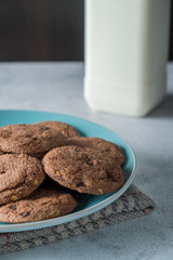 Delicious crunchy homemade chocolate cookies on a plate with cloth napkin, marble table with dark background. Rustic breakfast concept