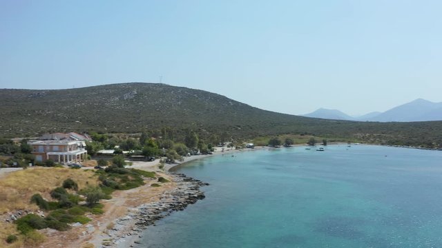 The seaside road by the waves and green mountain of the Eubea Island in Greece - aerial
