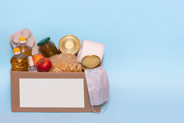 Food in a donation cardboard box, isolated on blue background,copy space. Coronavirus Relief Funds...