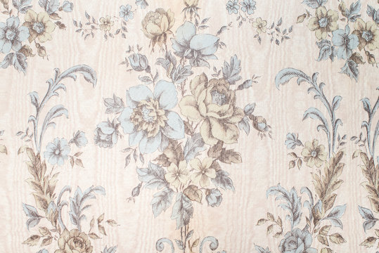 Old vintage wallpaper on the wall with a pattern of flowers