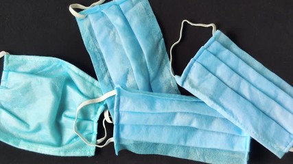 Overlay panning shot of four surgical masks on a black background - Powered by Adobe