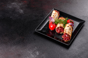 Delicious fresh beef tartar with toasts on a black square plate