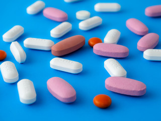 Obraz na płótnie Canvas Colored pills on a blue background top view.