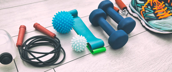 The fitness tools and  a equipment on the wooden floor. Concept of home physical training and staying at home - obrazy, fototapety, plakaty