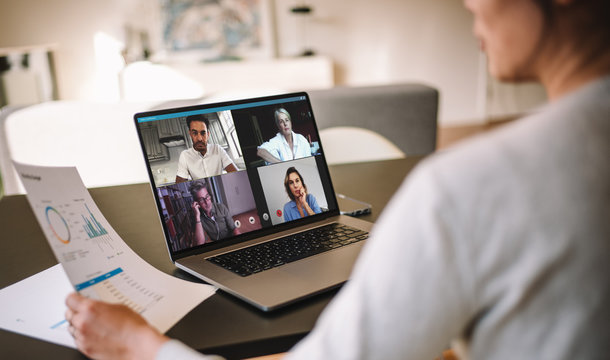 Woman discussing business with team over a video conference