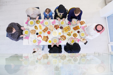 traditional muslim family praying before iftar dinner top view