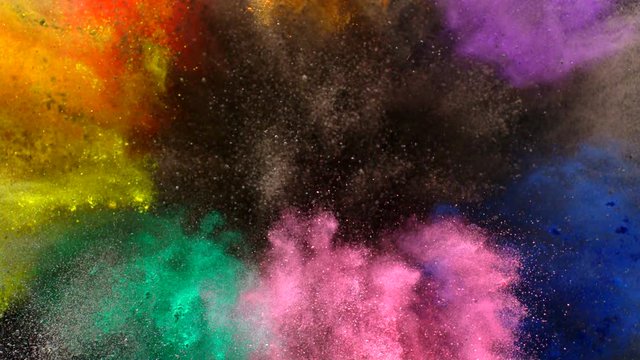 In real slow motion footage, a rainbow sea of colored powder (orange, yellow, grey, pink, purple , green) floats and combines in midair. Top Shot.