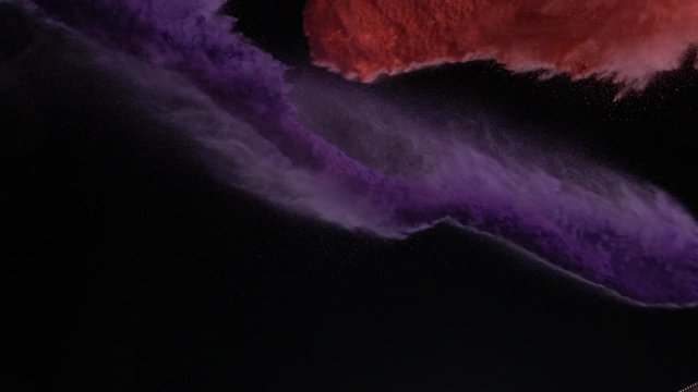 In real slow motion footage against a black background, a cup of purple powder and red powder are thrown from opposite sides at different heights to combine in the air. Side Shot