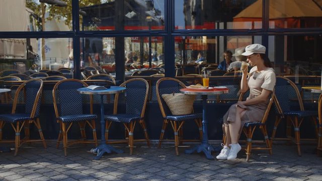 Attractive woman having breakfast in a cafe in the city