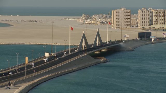 Wide high shot of the King Hamad Causeway to Muharraq. Busaiteen buildings in view.
