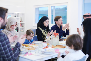 traditional muslim family praying before iftar dinner