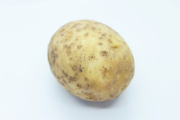 Raw ripe potatoes are located on a white background