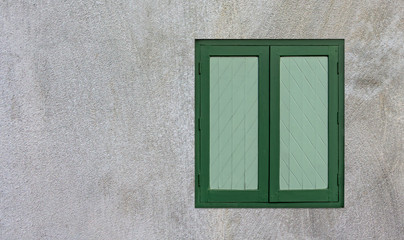 Green wooden windows are on the white cement wall with cope space for your text or image.