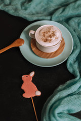 Cup of cappuccino with latte art on a dark background. Beautiful foam, blue, ceramic cup, stylish tinting.