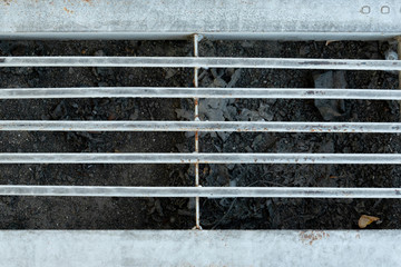 The pipe cover is a rusted metal grating.