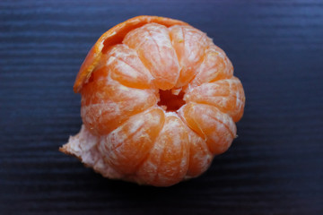 Fresh peeled Tangerine or Mandarin orange fruit isoleted on the table, top view, close up