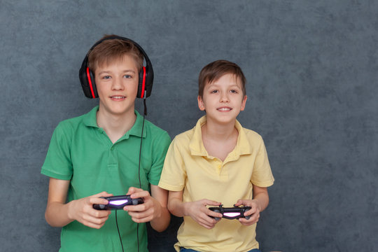 Two Friends Boys Enjoying Playing Videogame On Playstation, Resting At Home.