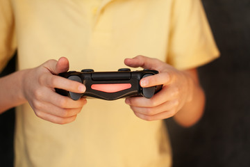 Boy holding joystick and playing video game, Resting At Home. © Volha Zaitsava