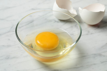 Raw egg in a bowl close up