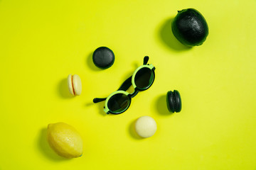 Macaroons and lemons. Monochrome stylish and trendy composition in yellow color on studio background. Top view, flat lay. Pure beauty of usual things around. Copyspace for ad. Holiday, food, fashion.