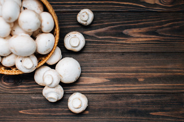 Dark wooden background with champignons. Copy space with mushrooms