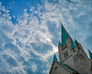 Tower of old Cathedral building in Wroclaw City with beautiful cloudy sky as background