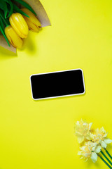 Flowers and phone. Monochrome stylish and trendy composition in yellow color on studio background. Top view, flat lay. Pure beauty of usual things around. Copyspace for ad. Holiday, food, fashion.