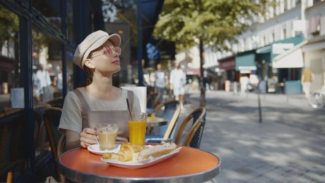Young woman having breakfast in Paris, France