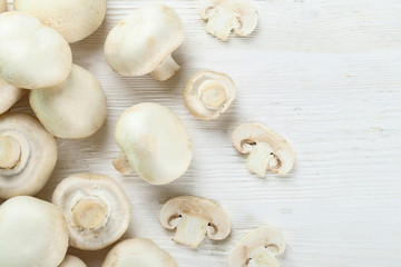 Fototapeta na wymiar Bunch of farm raised organic mushrooms laid in composition on textured background. Champignons on table counter. Clean eating concept. Background, close up, flat lay, top view.