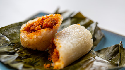 delicious Nan Yang sticky rice dessert, Temper Udage, Spicy Shrimp in glutinous rice roll on green leaf