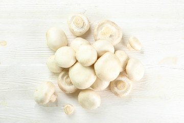 Bunch of farm raised organic mushrooms laid in composition on textured background. Champignons on table counter. Clean eating concept. Background, close up, flat lay, top view.