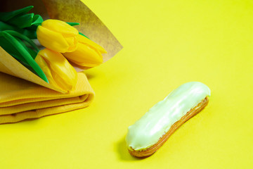Flowers and cake. Monochrome stylish and trendy composition in yellow color on studio background. Top view, flat lay. Pure beauty of usual things around. Copyspace for ad. Holiday, food, fashion.