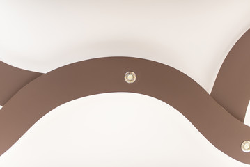 Stretch ceiling in light brown color with lamps.