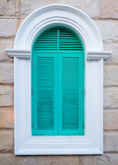 Fototapeta premium Green arched wooden window on the brick wall background.