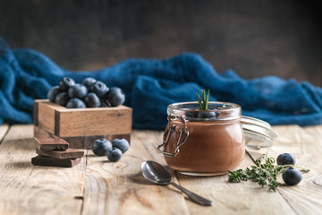 Chocolate mousse in glass jar with berries on a rustic background copy space. Homemade dessert.