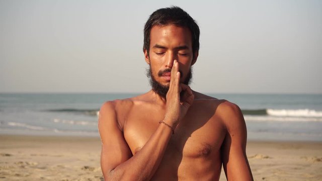 A man practices yoga and meditation in nature. Breathing exercises