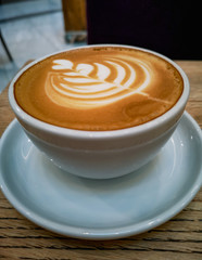 Tulip latte art on cafe latte on wooden table