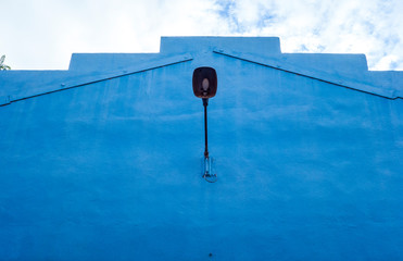 lamppost on blue wall and sky