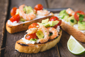 Sandwich with vegetables and prawns. Bruschetta with avocado and shrimp