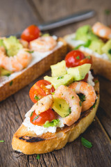 Sandwich with vegetables and prawns. Bruschetta with avocado and shrimp