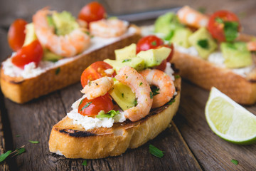 Sandwich with vegetables and prawns. Bruschetta with avocado and shrimp