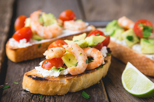 Sandwich with vegetables and prawns. Bruschetta with avocado and shrimp