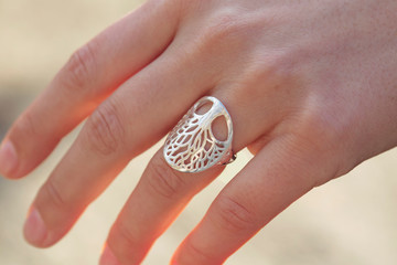 Female hand wearing beautiful silver ring in the shape of the tree