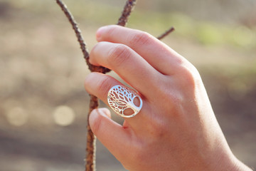 Female hand wearing beautiful silver ring in the shape of the tree