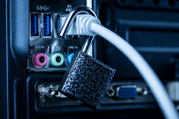 Opened lock hanging on a network cable plugged into a computer. The concept of opening access,...
