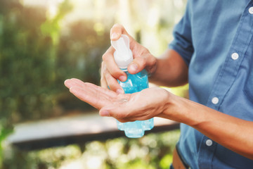 A man using alcohol based hand sanitizer for cleaning hands before working. Anti bacteria and protect from Coronavirus Disease 2019 (COVID-19) virus outbreaks.