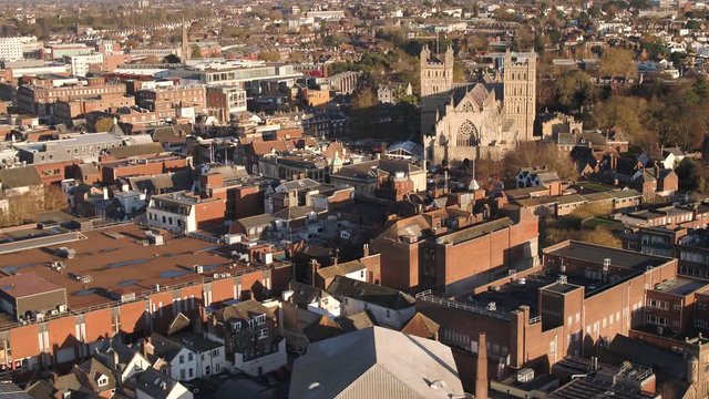 Aerial of Exeter city. Its built up city centre and cathedral dominate the foreground. Wide horizon of the town.