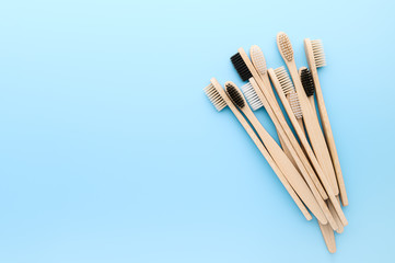 Zero waste and without plastic concept. Set of eco friendly bamboo toothbrushes on light pastel blue surface. Top view, copy space, horizontal orientation. Layout natural organic hygiene products.