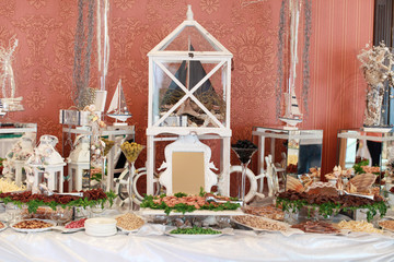 Beautifully decorated catering banquet table with profiteroles, salads and cold snacks. Variety of tasty delicious snacks on the table. Wedding table serving. Meat and vegetables